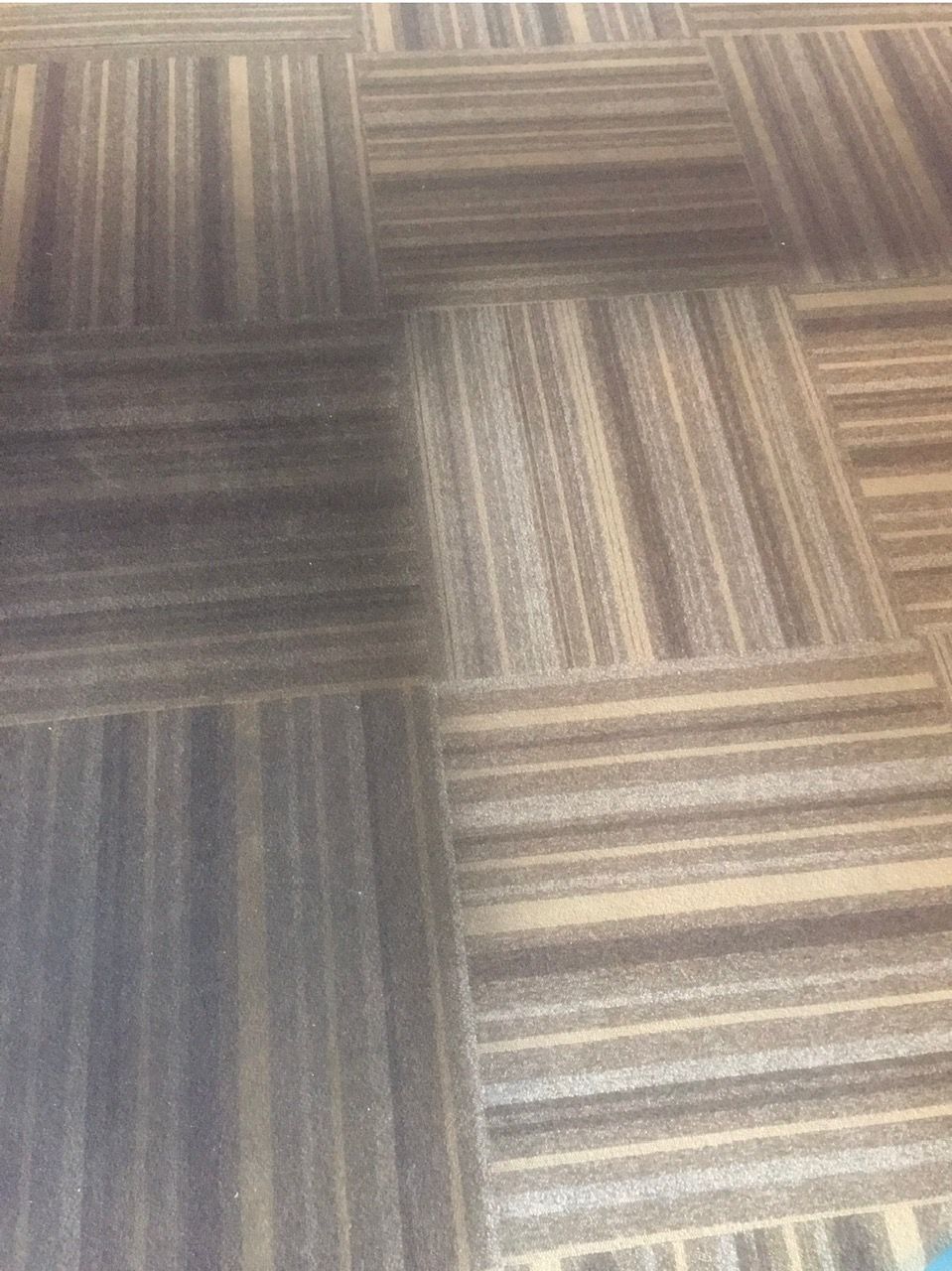A close up of a carpeted floor with a striped pattern.