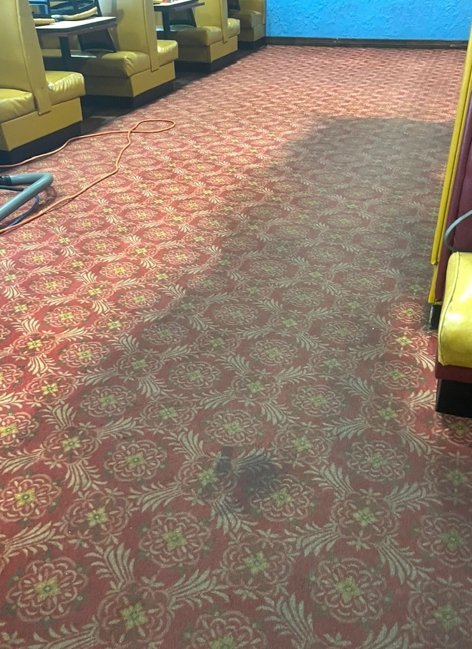 A restaurant with a red carpet and yellow chairs.