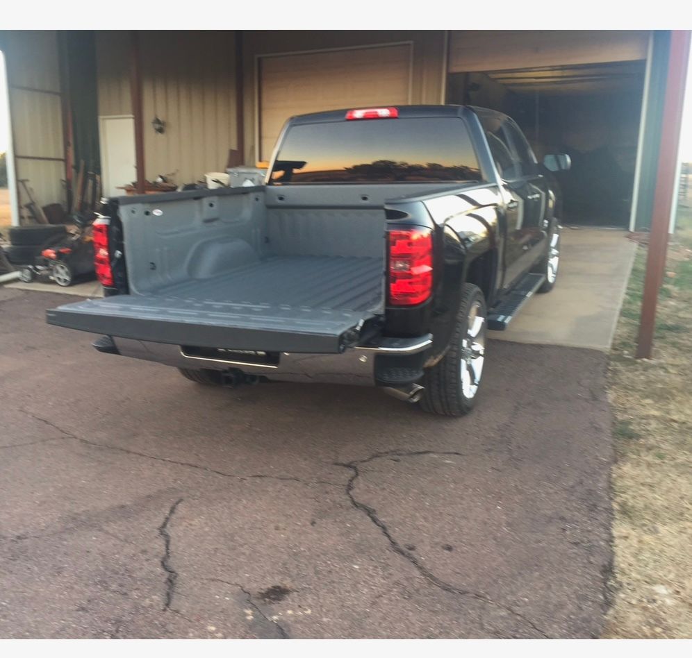 A black truck is parked in front of a garage