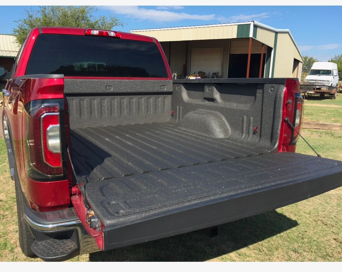 The back of a red truck with the bed open