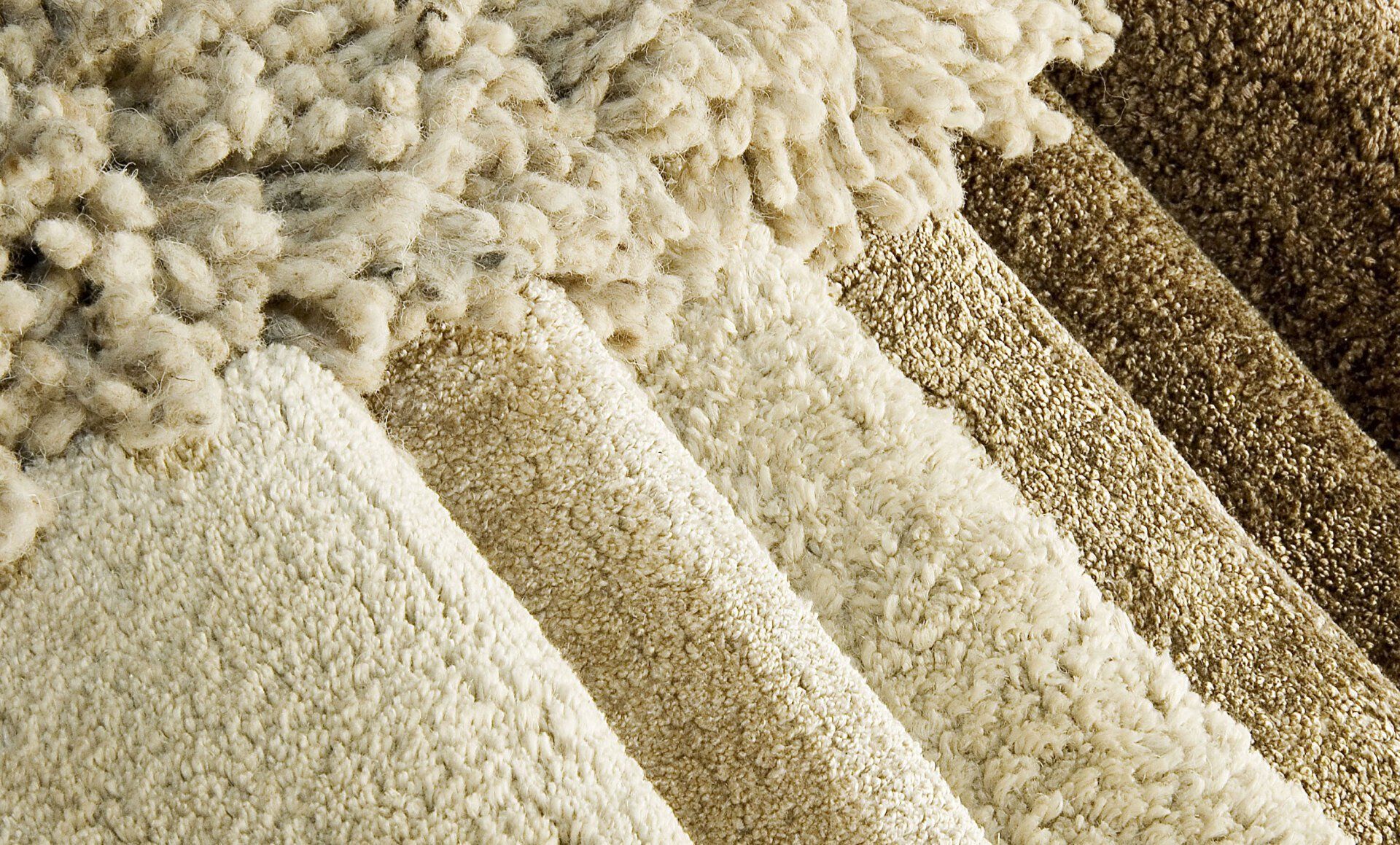 A bunch of different colored carpets are stacked on top of each other.