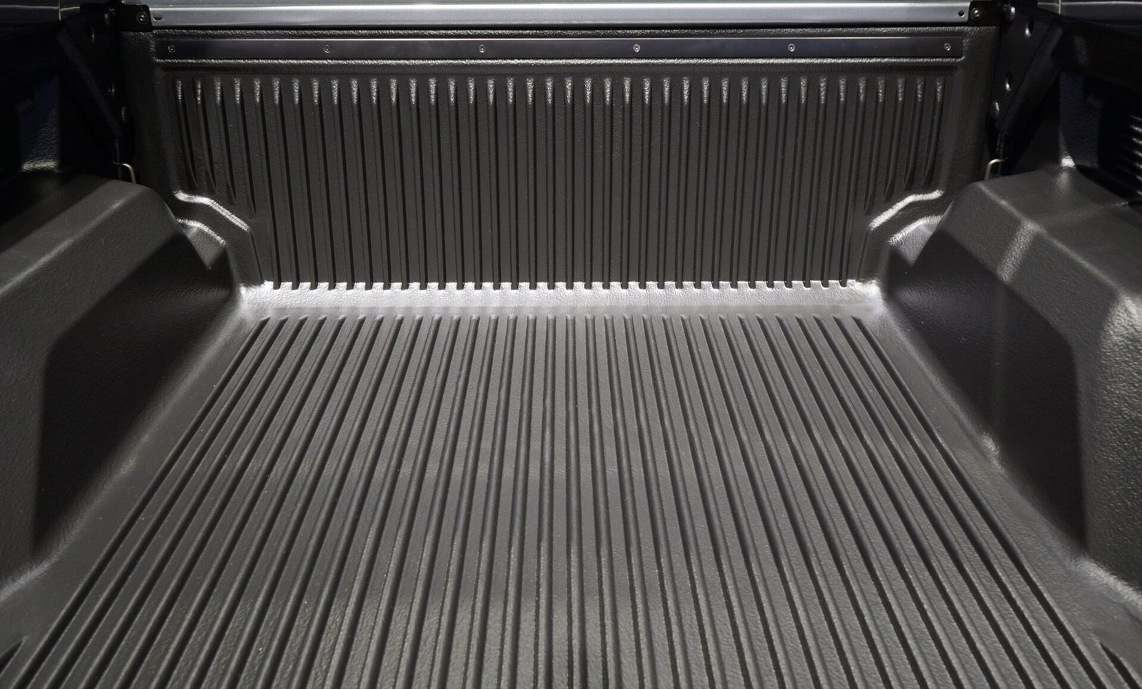 The back of a truck with a rubber bed mat.