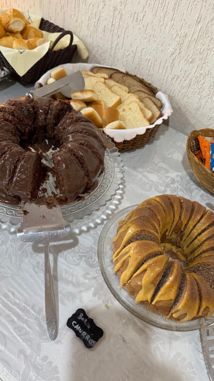 Diversos bolos e doces em forma de bolo Bundt dispostos sobre uma mesa, incluindo variedades de chocolate, baunilha e com cobertura.