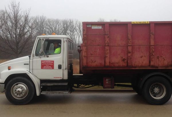 a white dump truck with a red dumpster on the back