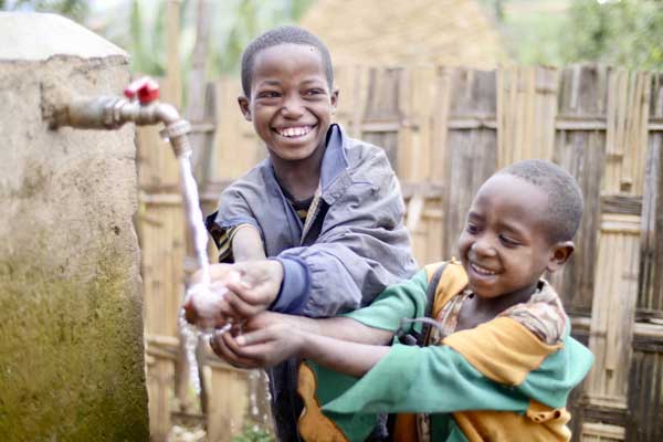 Happy Ethiopian boys with well