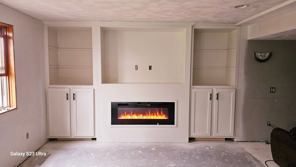 A living room with white cabinets and a fireplace