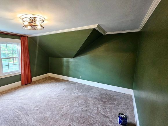 An empty room with green walls and a window