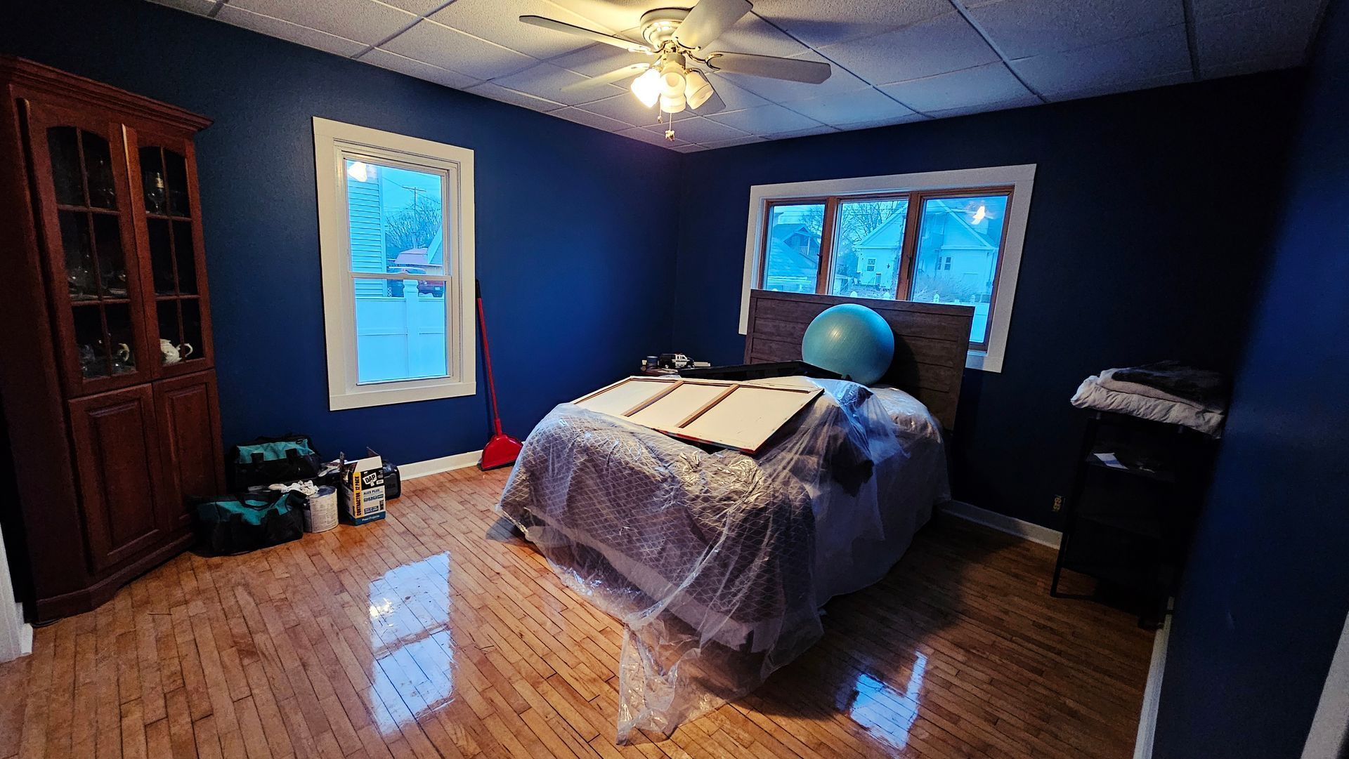 A bedroom with a bed and a ceiling fan