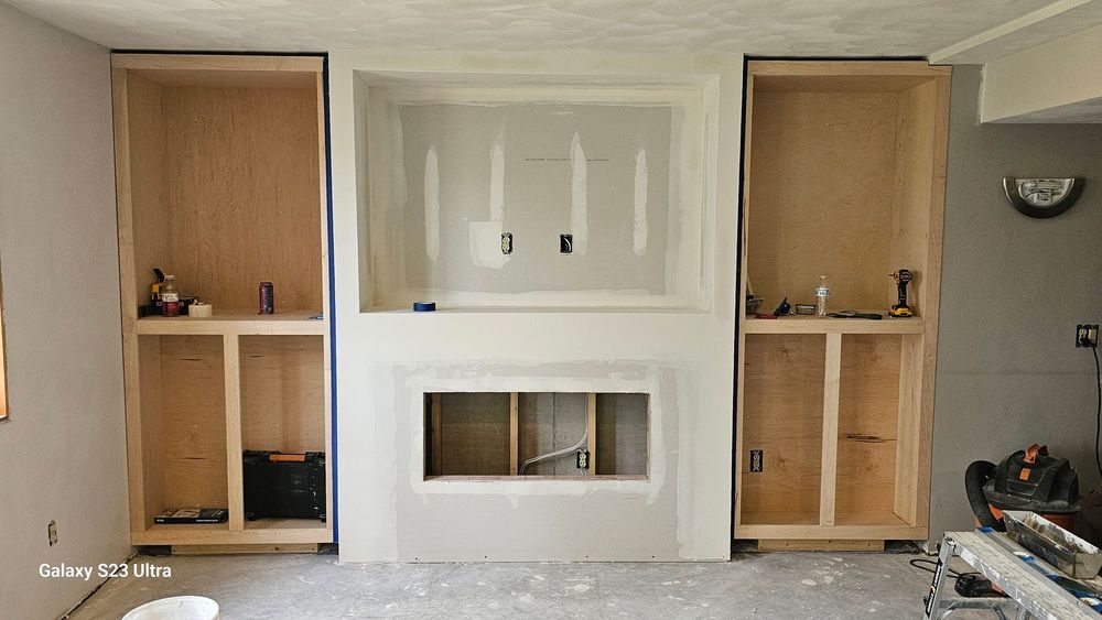 A living room with a fireplace and built in shelves