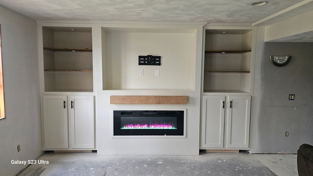 A living room with white cabinets and a fireplace