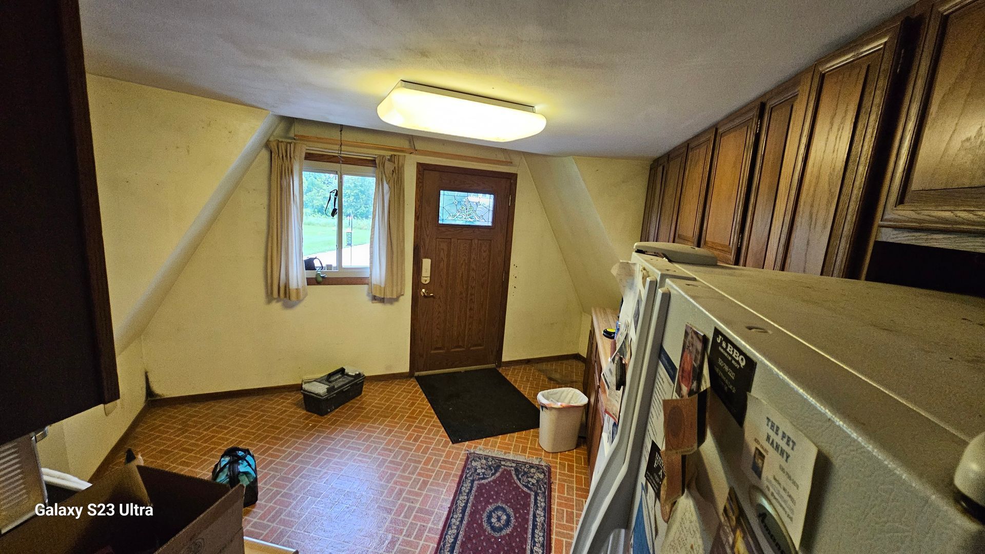 A room with a door and a refrigerator in it