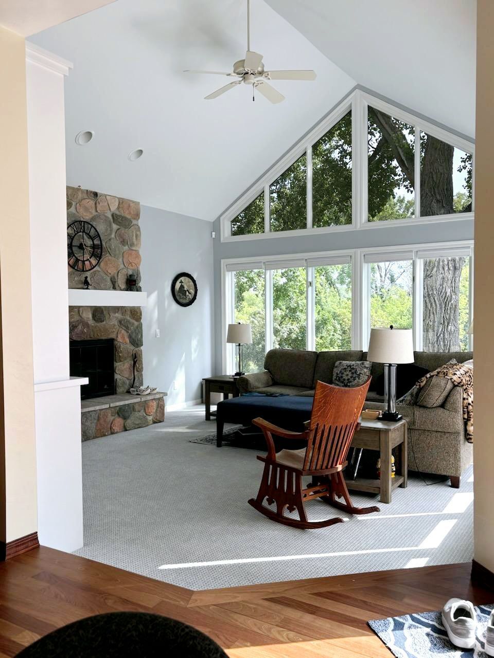 A living room with a rocking chair and a ceiling fan