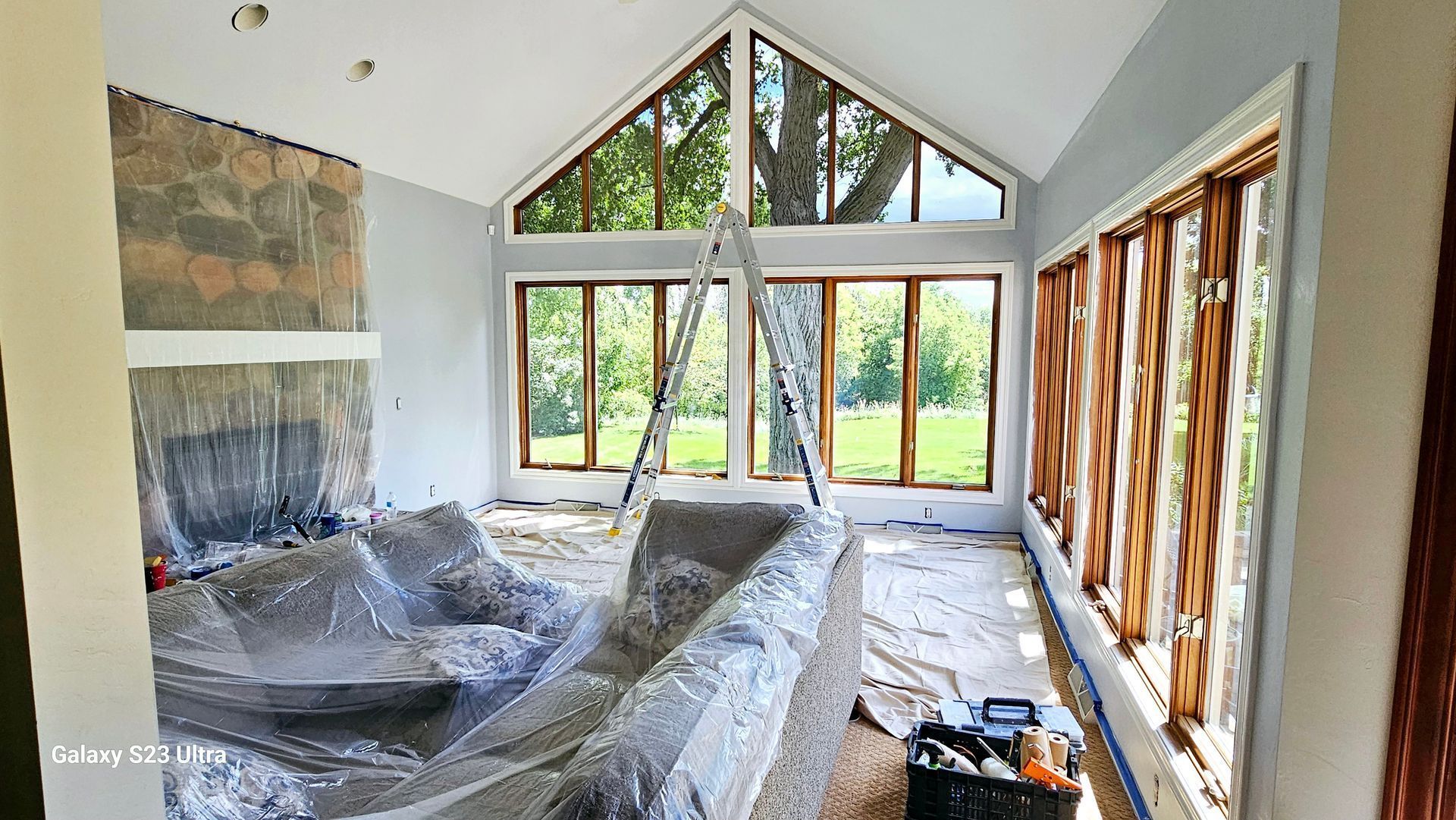 A large room with a lot of windows and a ladder