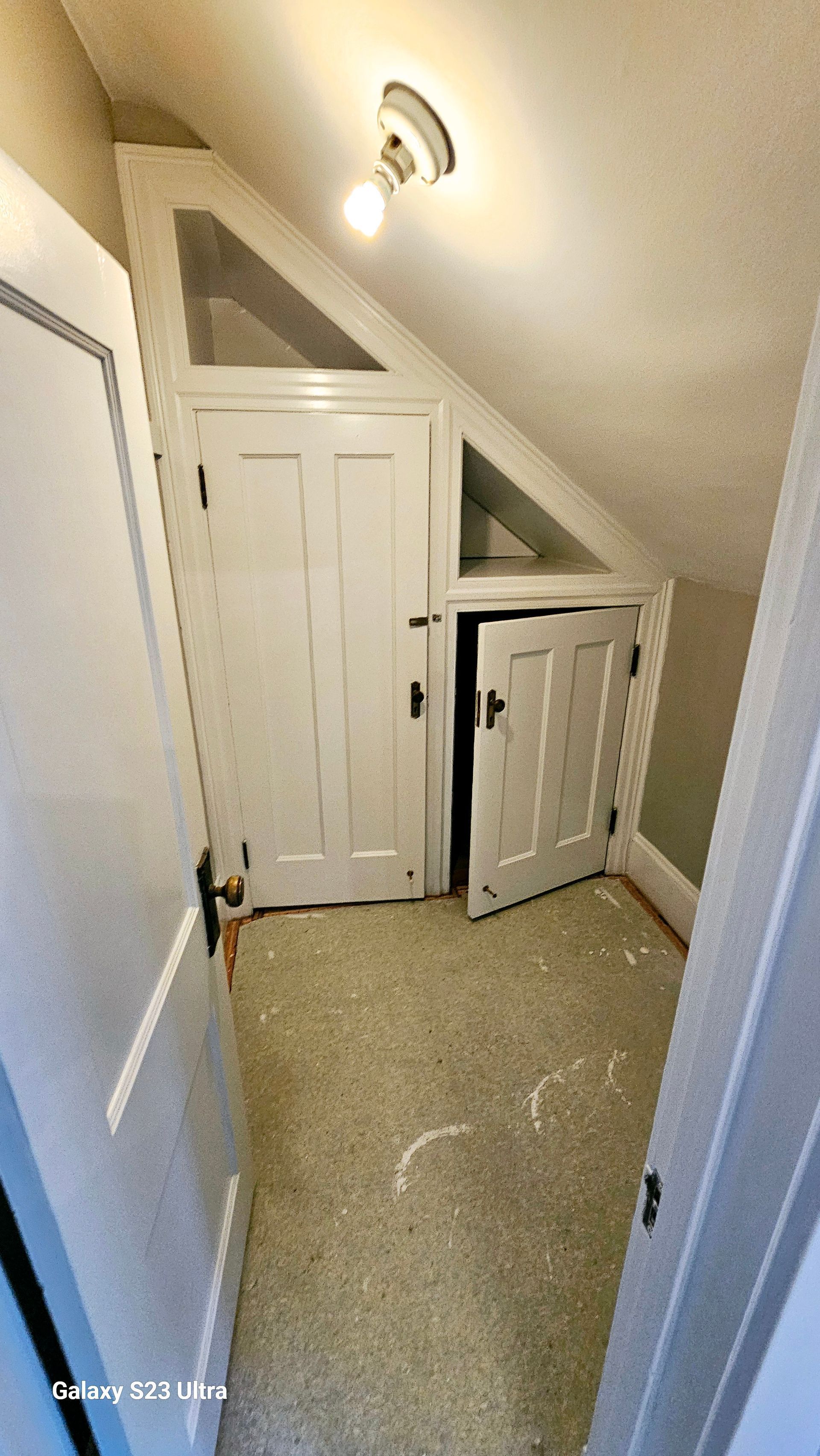 A room with a slanted ceiling and a door that is open