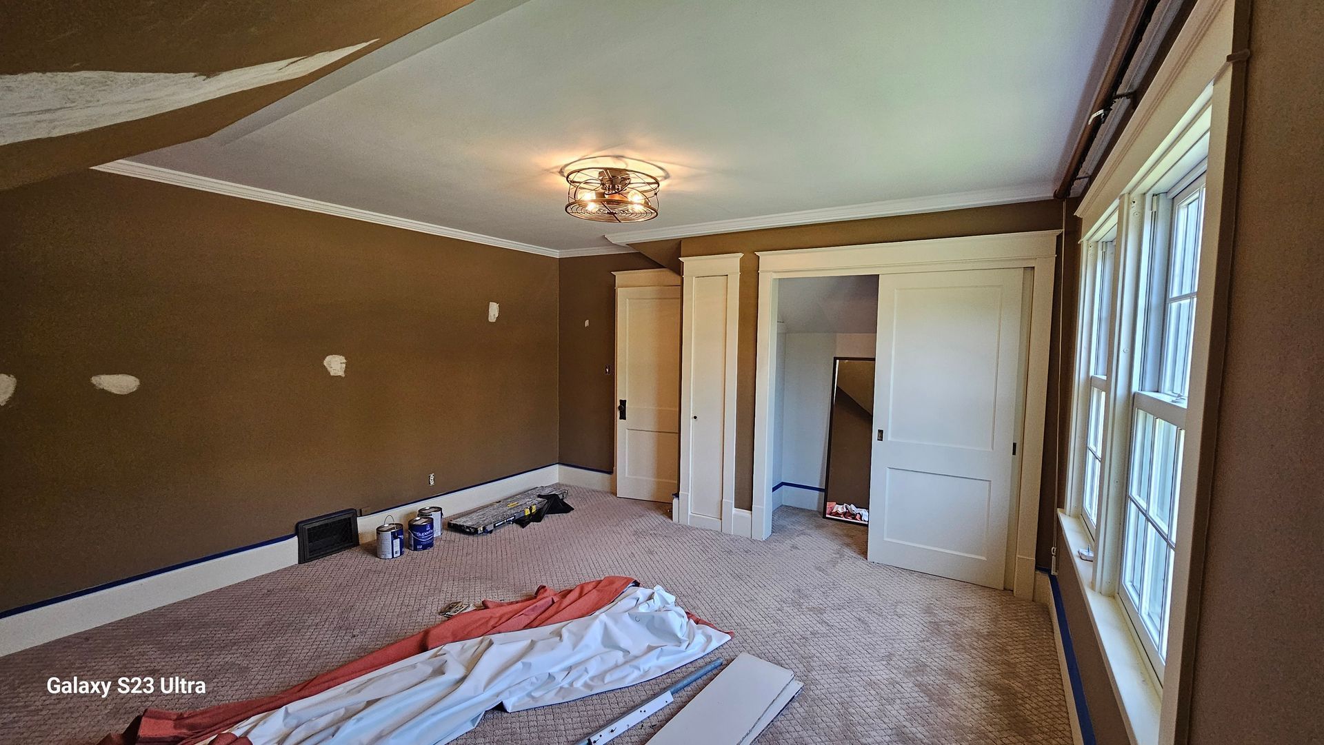 An empty room with a lot of windows and a ceiling light