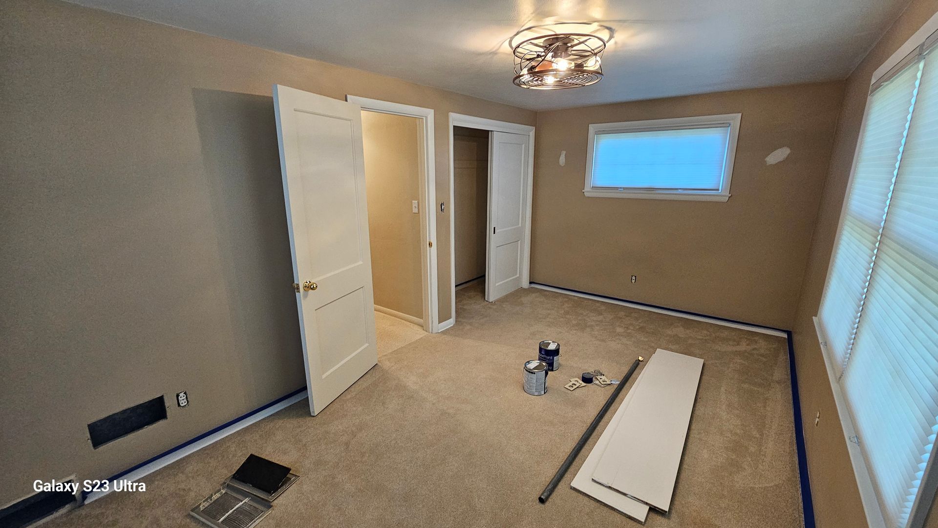 An empty room with a window and a ceiling light