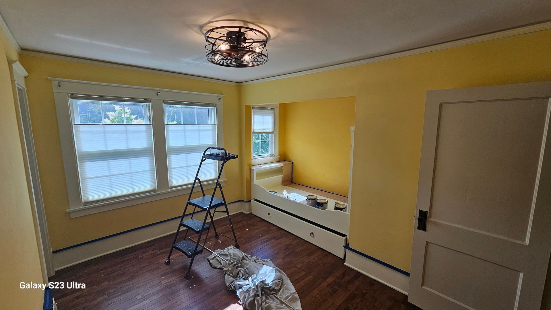 A room with yellow walls and a ladder in it