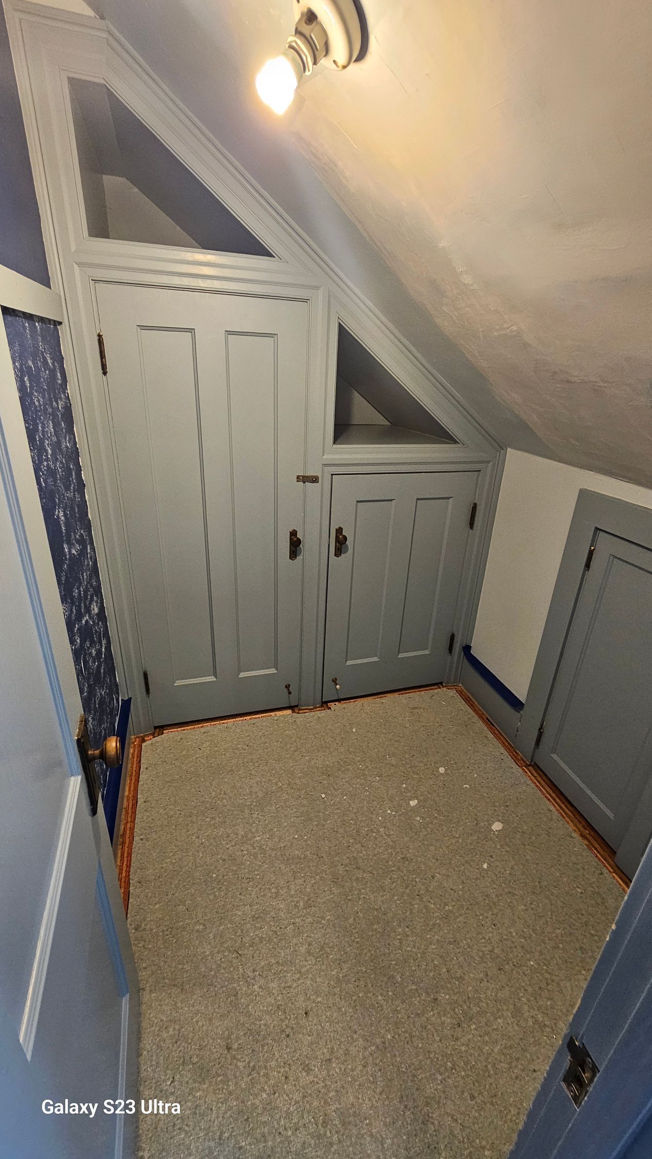 A room with a slanted ceiling and a light on the ceiling