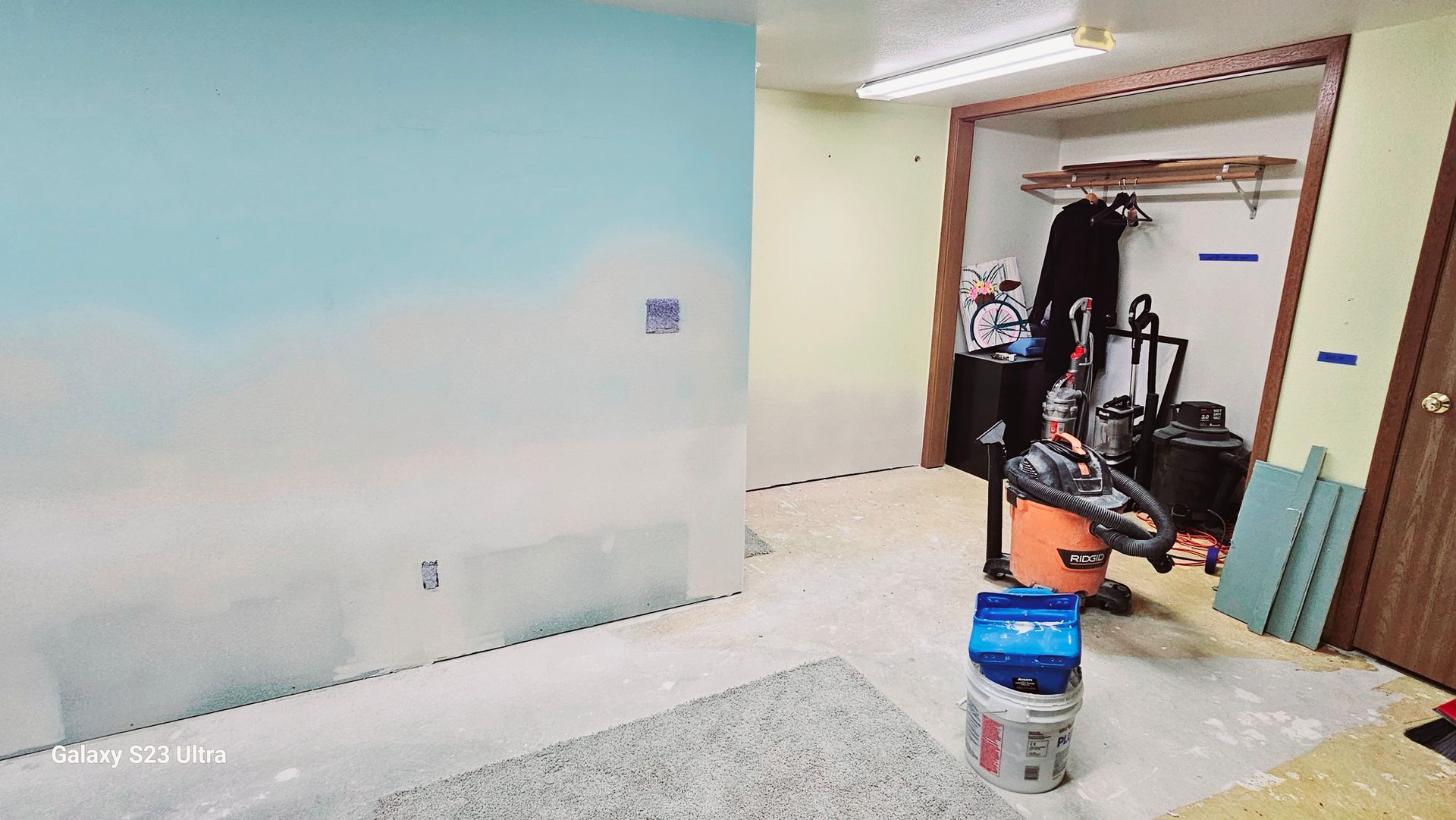 A person is standing in a room with a vacuum cleaner