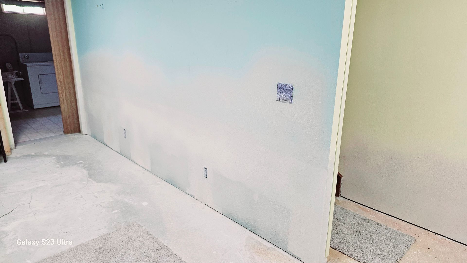 A room with a blue wall and a white wall