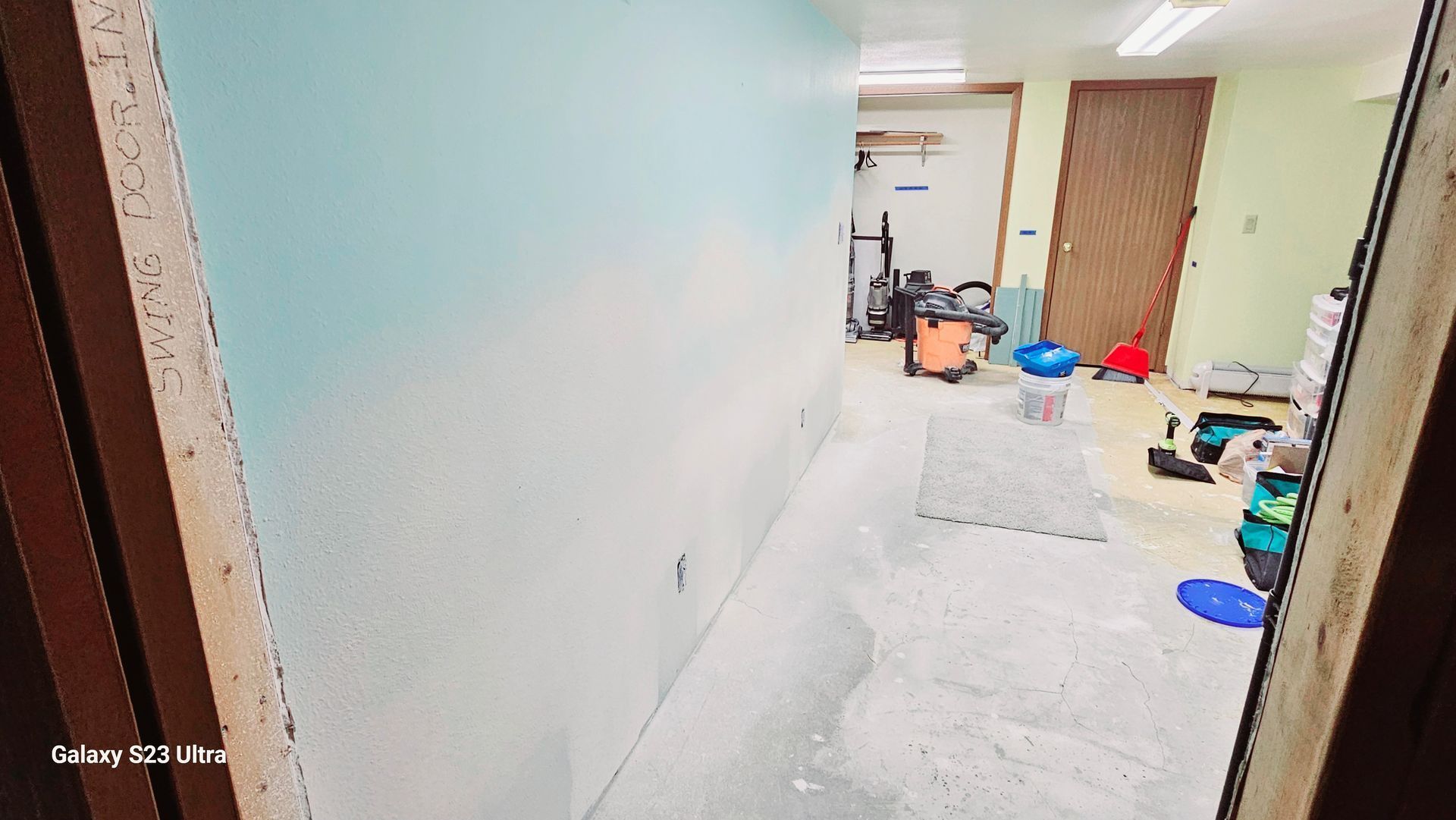 A room with a vacuum cleaner on the floor and a door