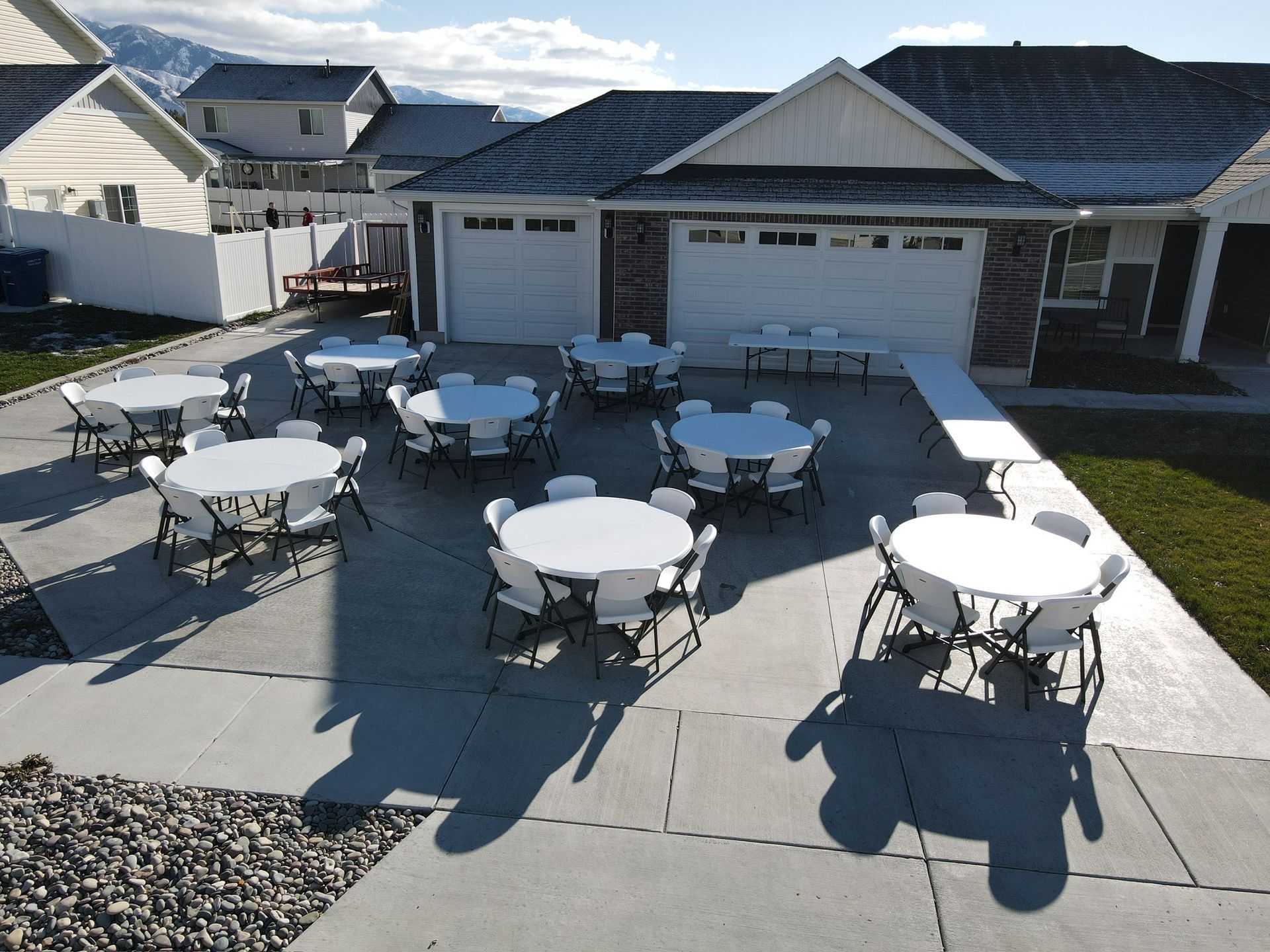 Backyard event setup with round tables and chairs arranged for a private gathering