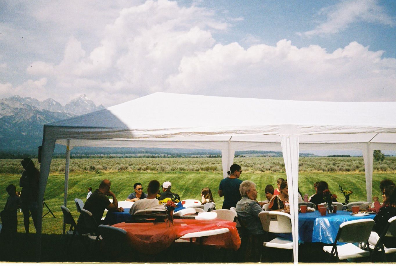 Tent and shade rental setup with tables and chairs for an outdoor event