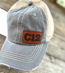 A baseball cap with a leather patch on it is sitting on a wooden table.