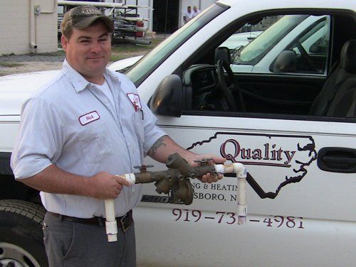 Plumber Holding A Pipe — Goldsboro, NC — Quality Plumbing & Heating Co.