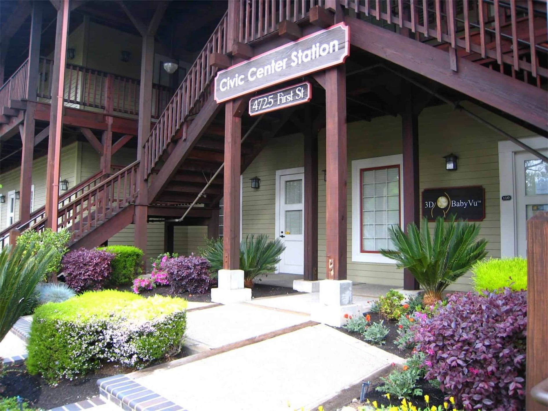 Wooden stairs lead up a light green building labeled 