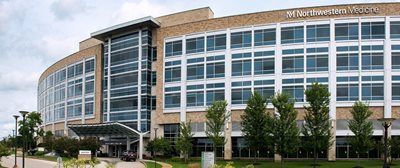 Exterior view of Northwestern Medicine hospital building. Modern design with glass windows and a curved facade.