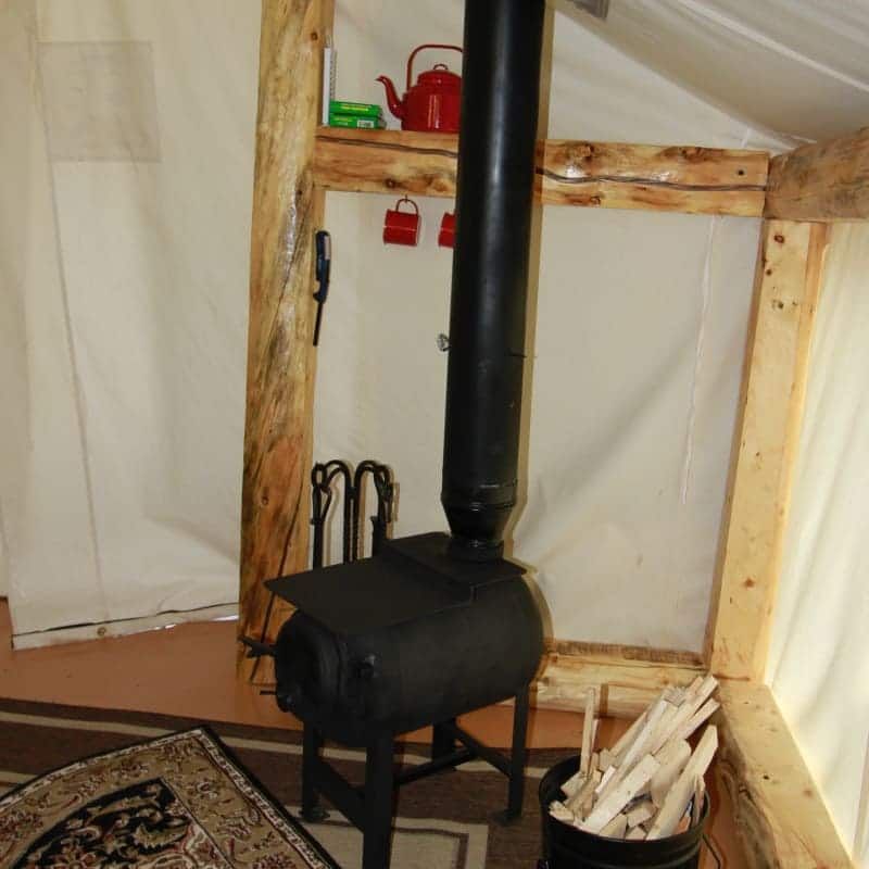 A black stove is sitting in a room next to a window