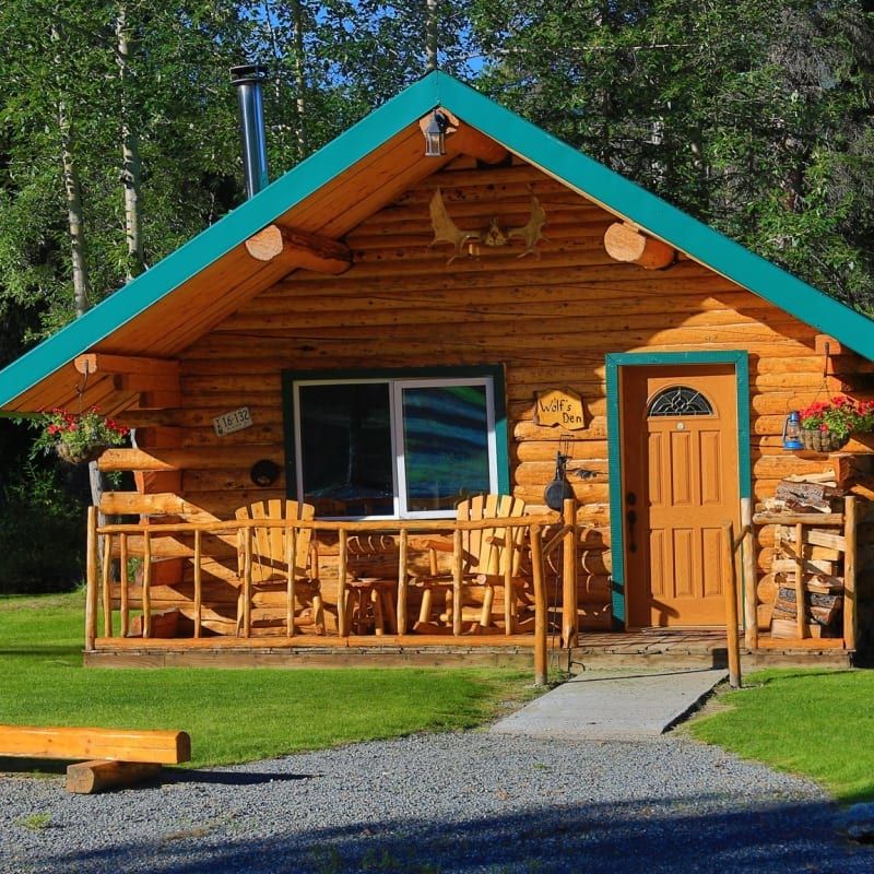 A small log cabin with a blue roof and a sign that says
