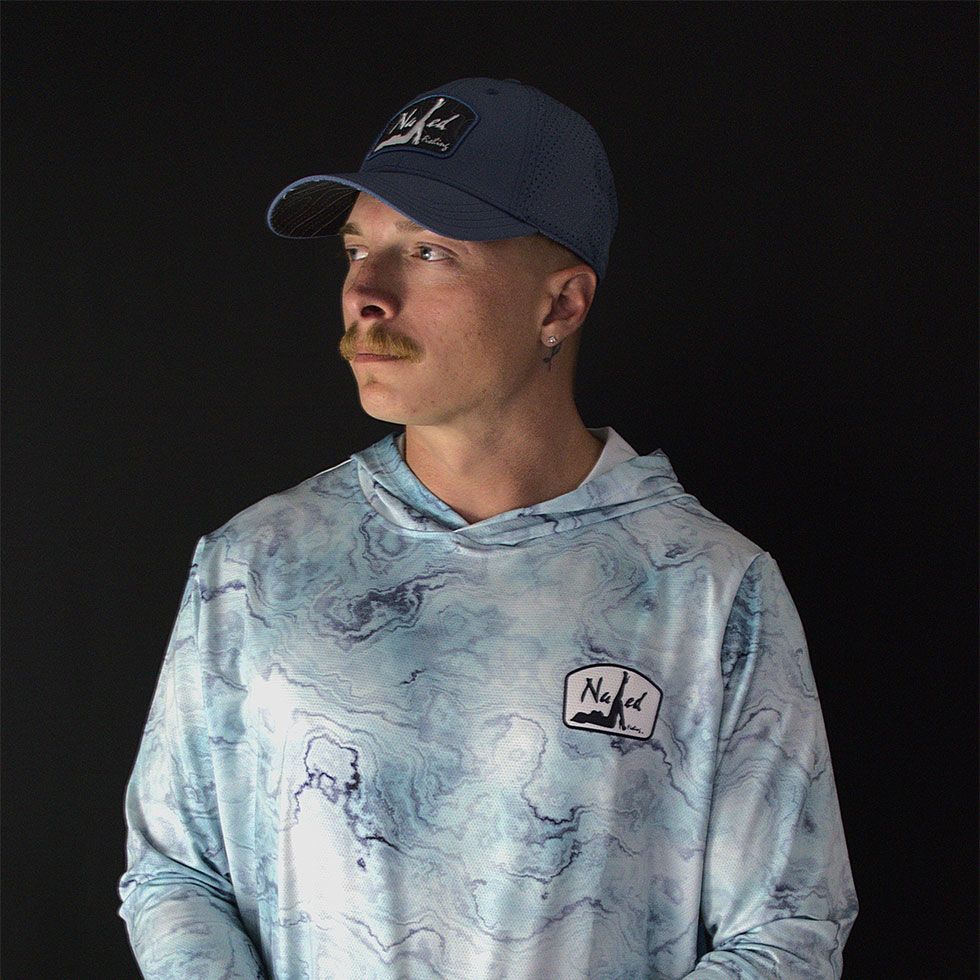 A man in a white shirt is fishing in the ocean