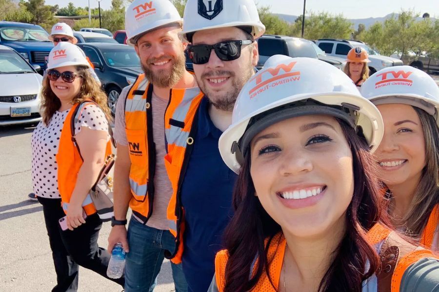 Group of leadership henderson professionals wearing hard hats and smiling.