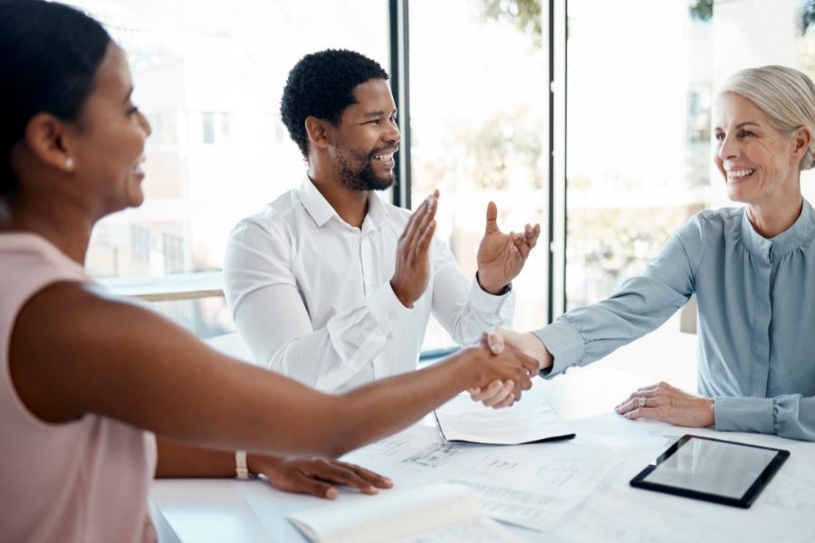 Diverse professionals shaking hands and celebrating business deal