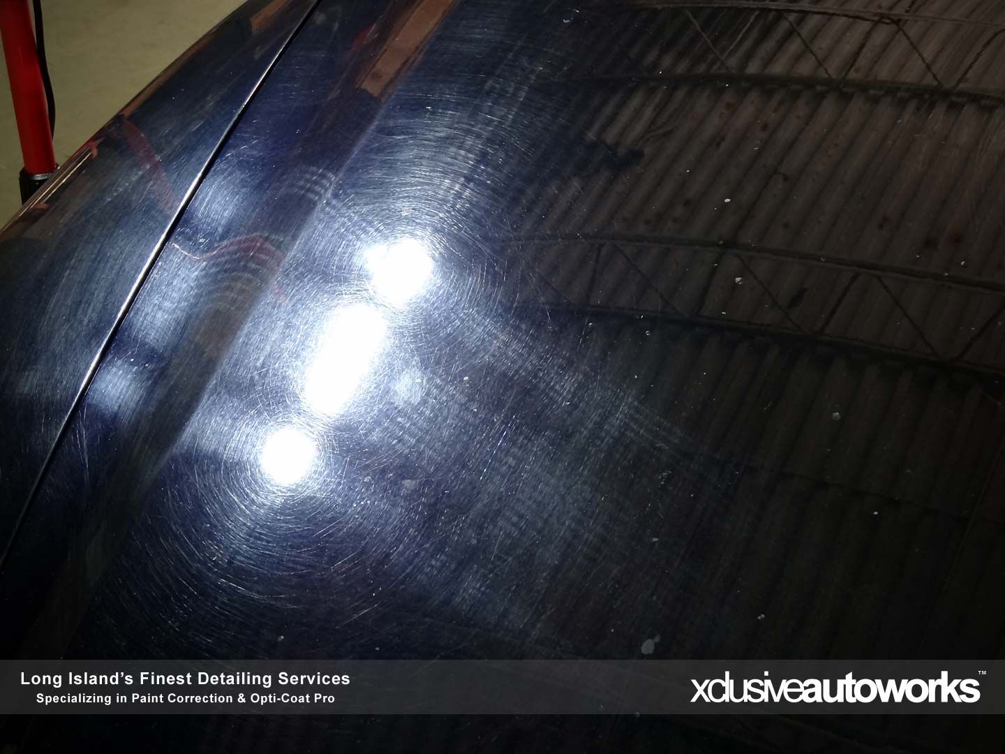 A close up of a car hood with xclusive autoworks written on the bottom