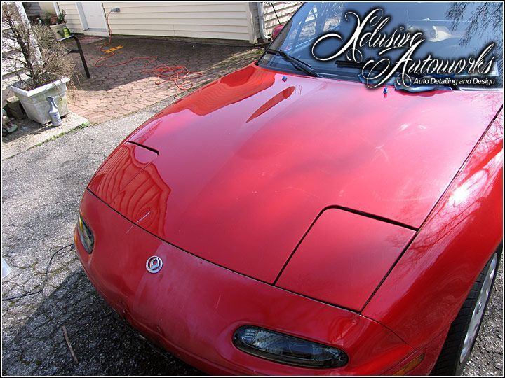 A red sports car is parked in front of a house
