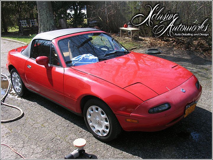 A red sports car is parked on the side of the road