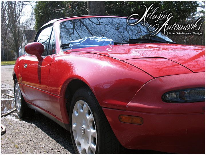 A red sports car is parked on the side of the road