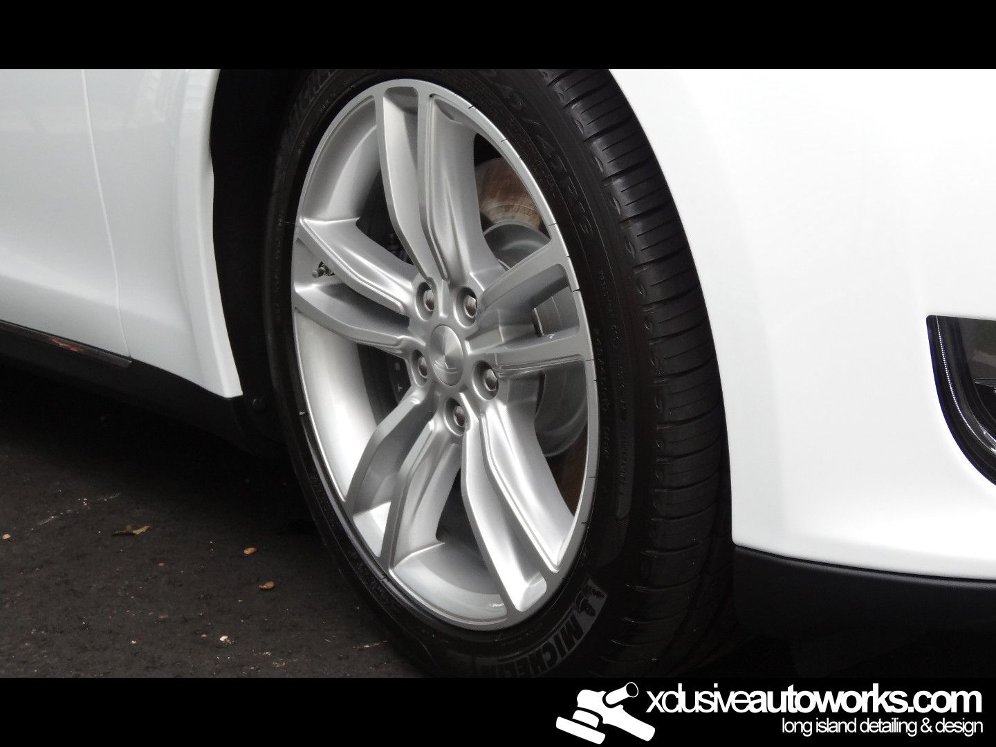 A white car with a michelin tire on it