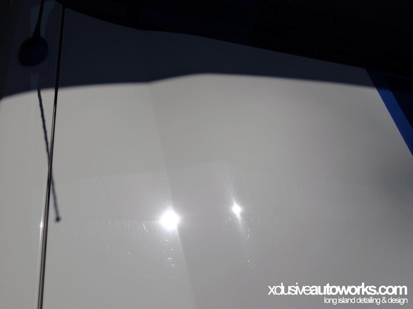 A close up of a white surface with xdusveautoworks.com written on the bottom