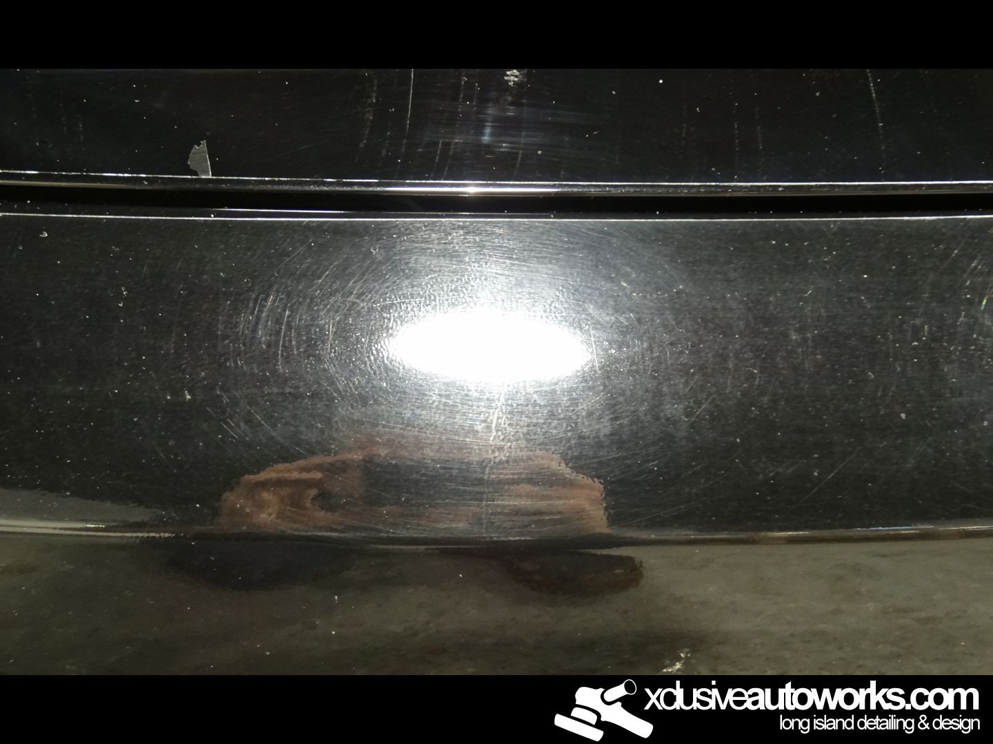 A close up of a black car with the website xdusveautoworks.com on the bottom