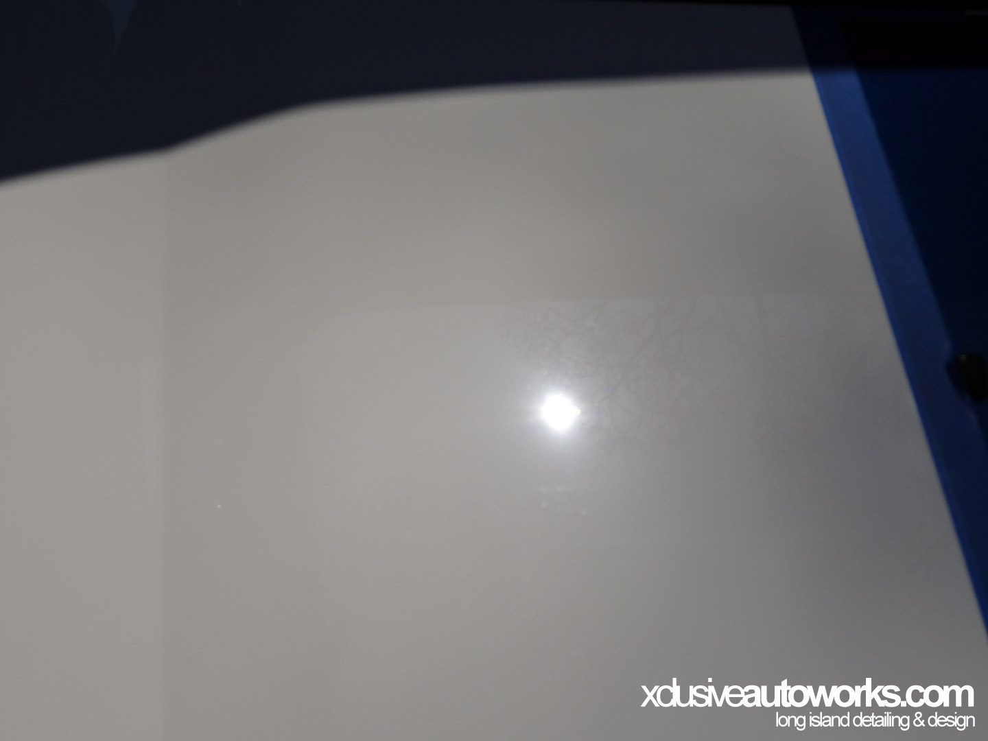 A white surface with xclusiveautoworks.com written on it