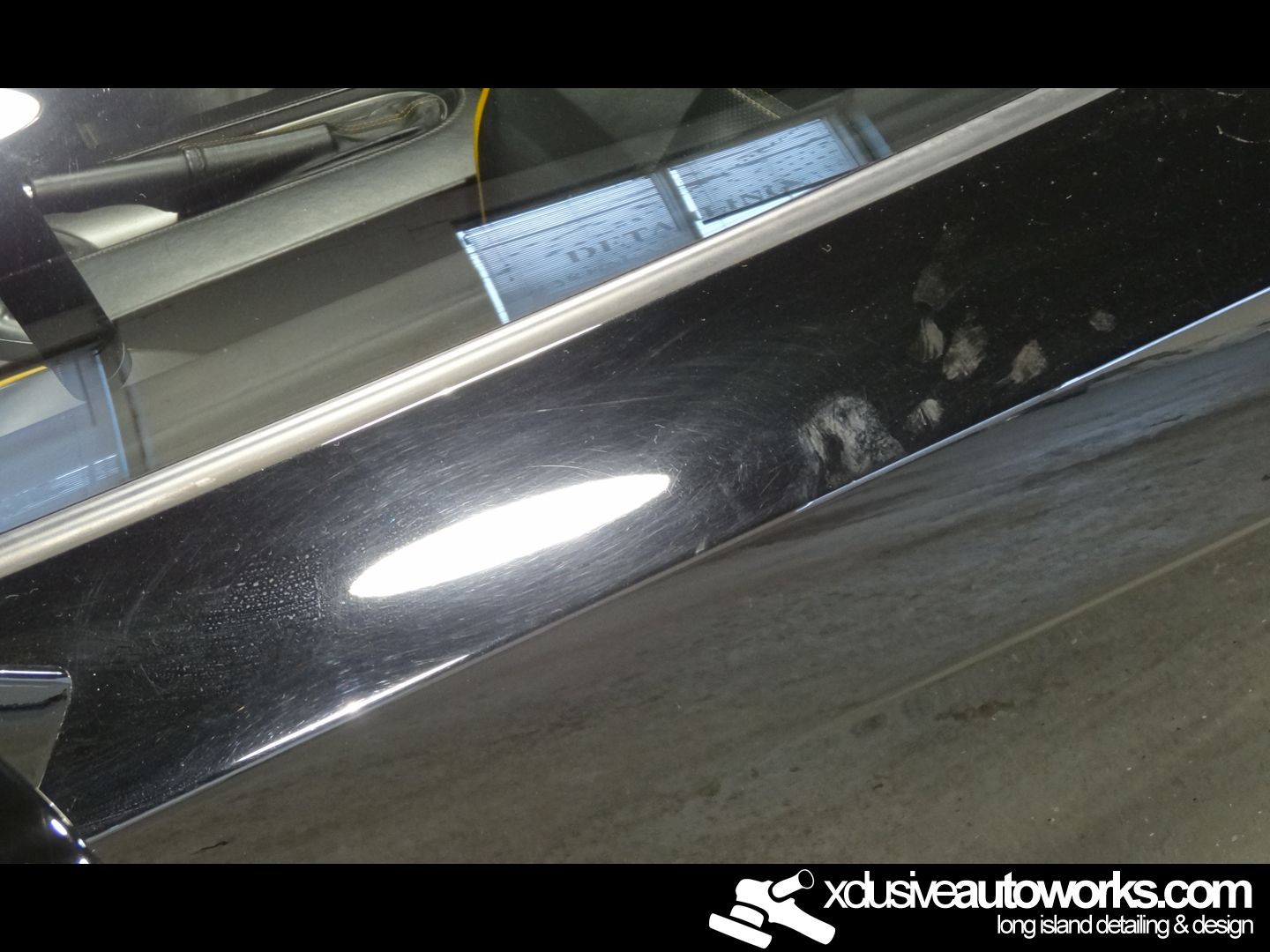 A close up of a black car with the website xdusveautoworks.com on the bottom