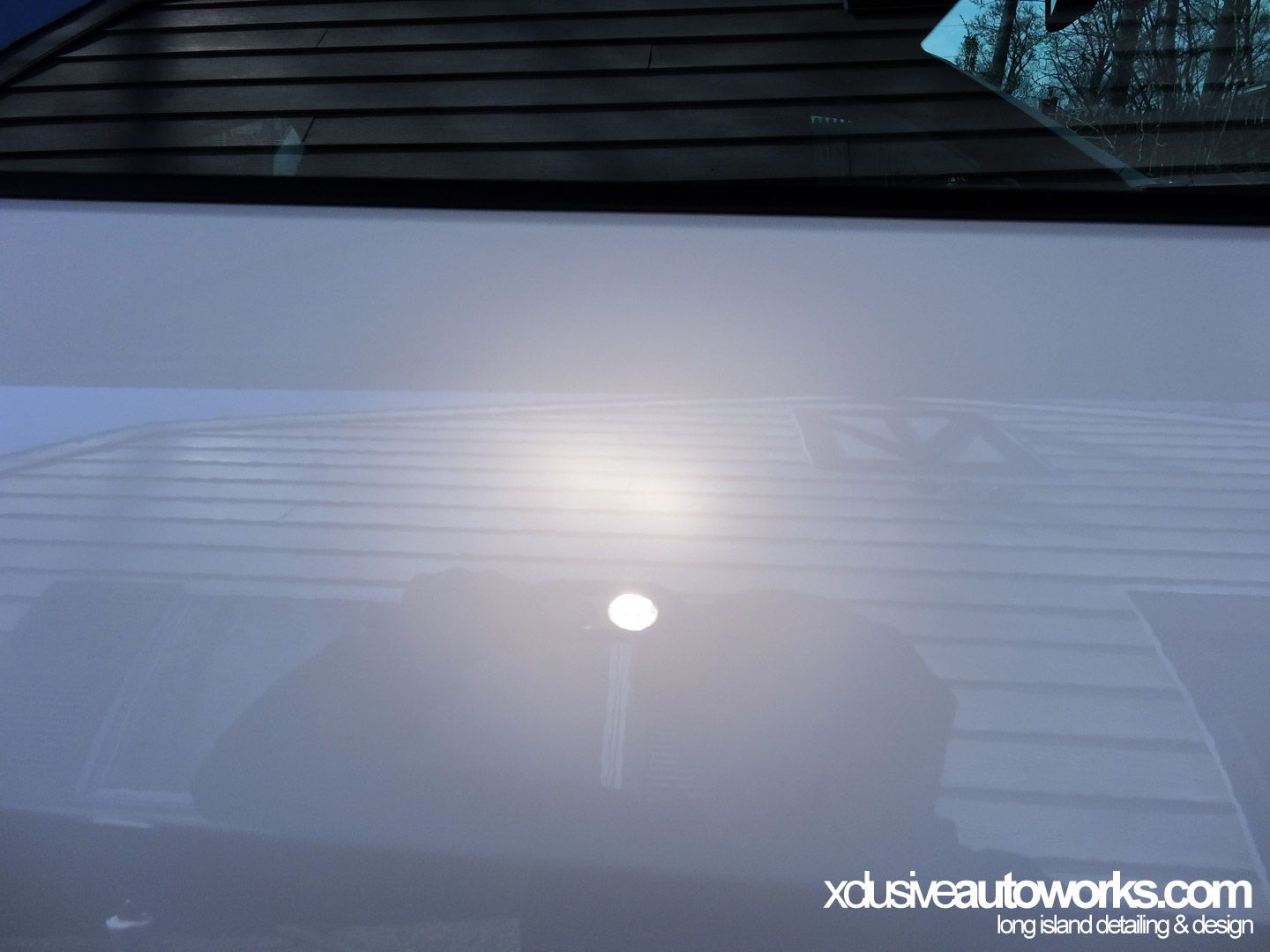 A white car with the website xdusveautoworks.com on the bottom