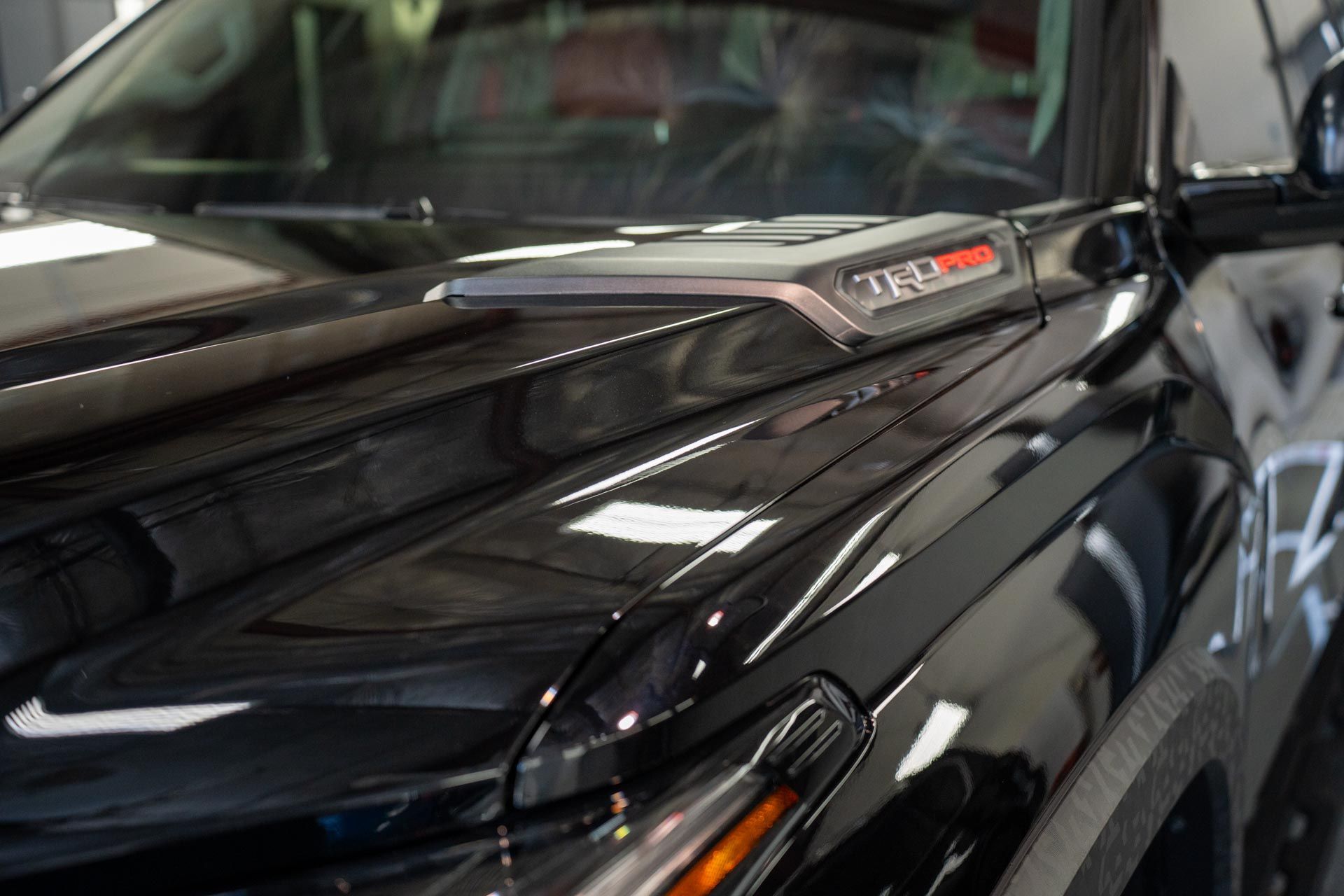 A close up of a black truck parked in a garage.