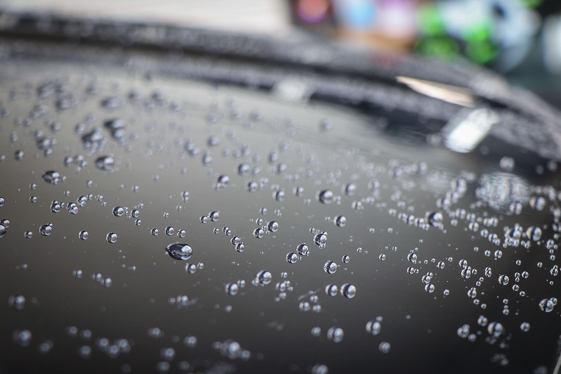 A close up of water drops on a black surface.