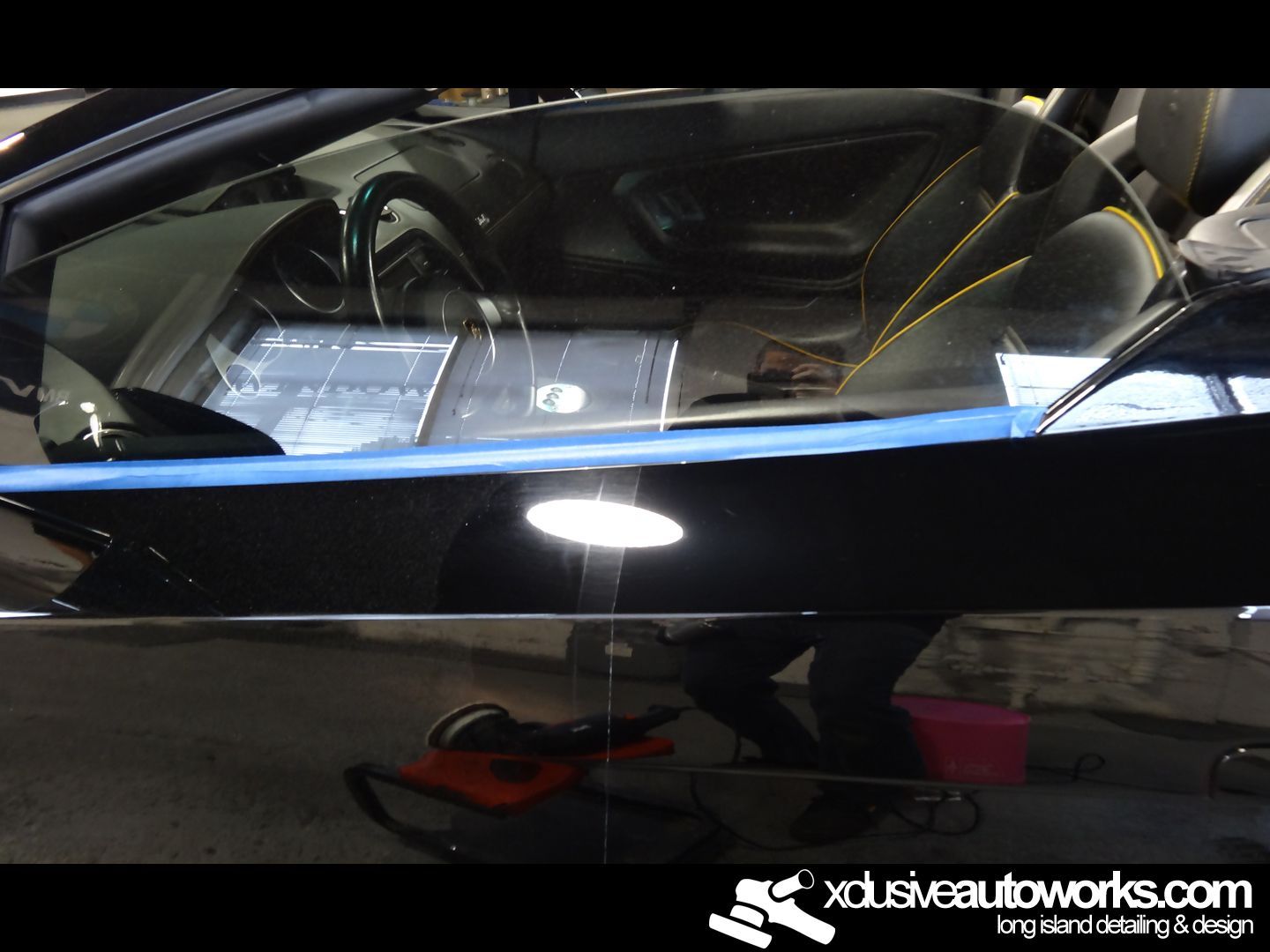 A black car is being cleaned by xdusveautoworks.com