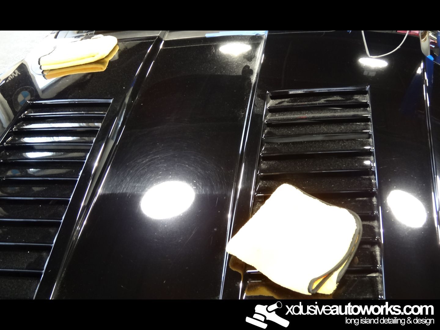 A black car is being cleaned by xdusveautoworks.com